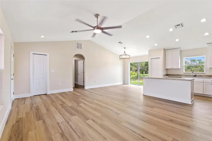 The cathredal ceilings add great volume space!  The door to the left is a storage closet.  The arched opening leads into the guest section where you will find two bedrooms and full guest bath.