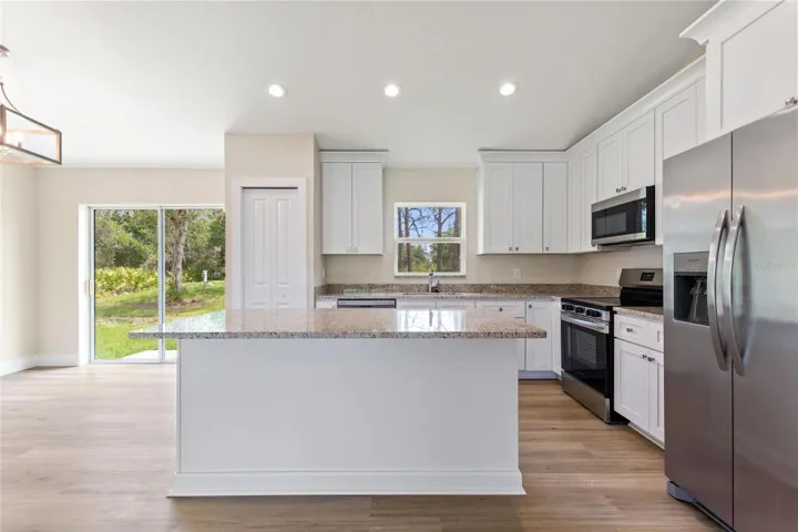 Beautiful kitchen with closet pantry, stainless steel appliances, granite countertops, soft-close drawers and  42-inch cabinets with crown molding.