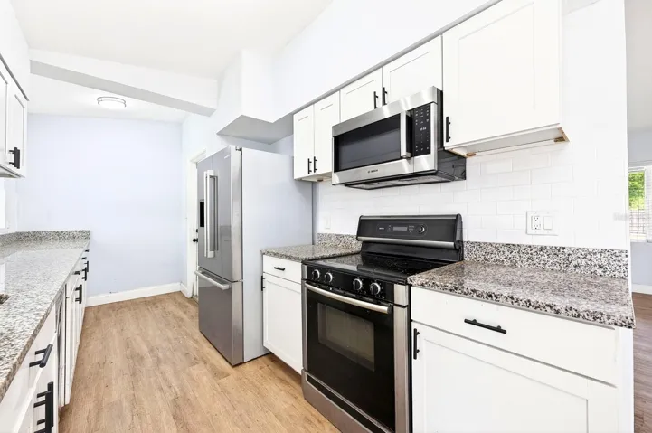 The fully REMODELED KITCHEN steals the spotlight with GRANITE COUNTERTOPS, desirable shaker style cabinetry, a designer TILE BACKSPLASH, and upgraded Bosch STAINLESS STEEL APPLIANCES – a rare level of finish at this price point.