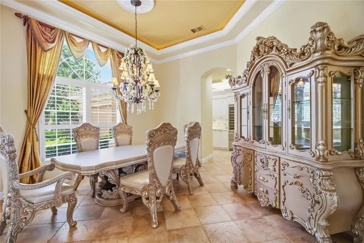 Formal dining area framed by columns, natural light, and graceful ceiling detail.