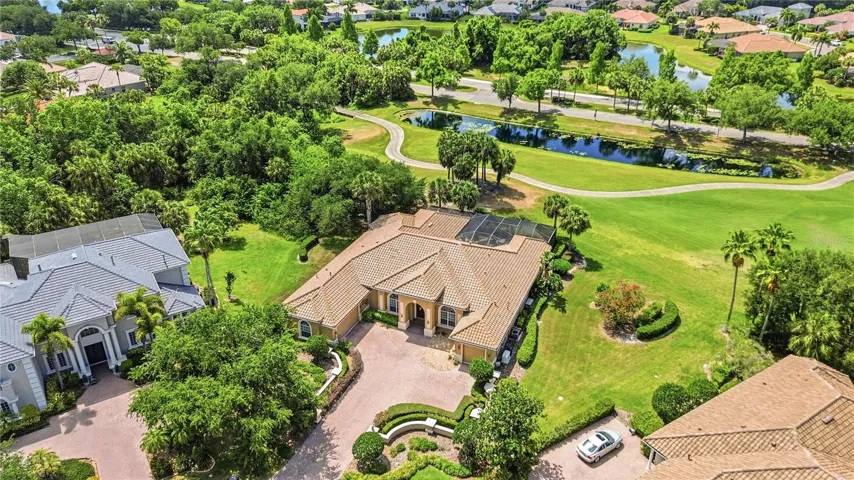 Aerial view of the home, pool, and lush landscaping on a private cul-de-sac lot.