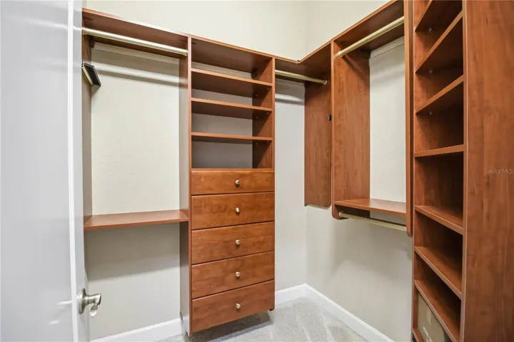 Dual walk-in closet with custom built-ins and generous organized storage.