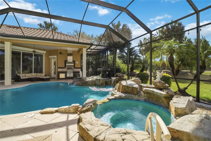 Pool and spa retreat framed by mature landscaping and peaceful golf course views.