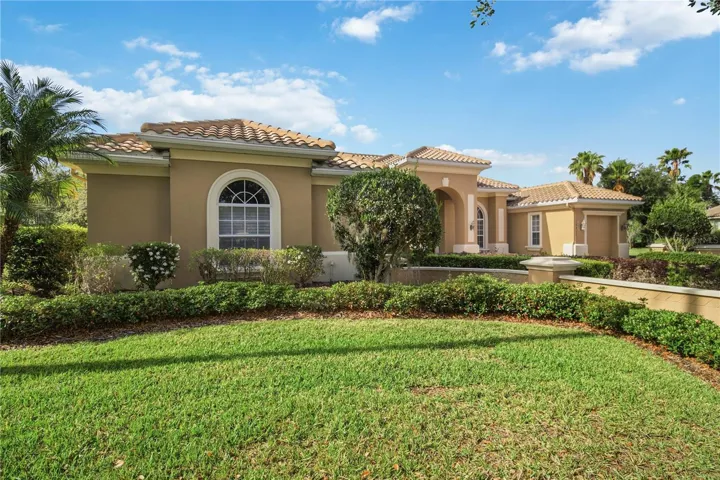Elegant front elevation set back with mature landscaping and a welcoming drive.