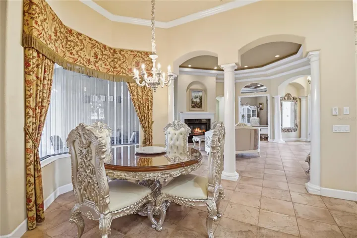 Graceful eat in area with arched details, warm finishes, and natural light.