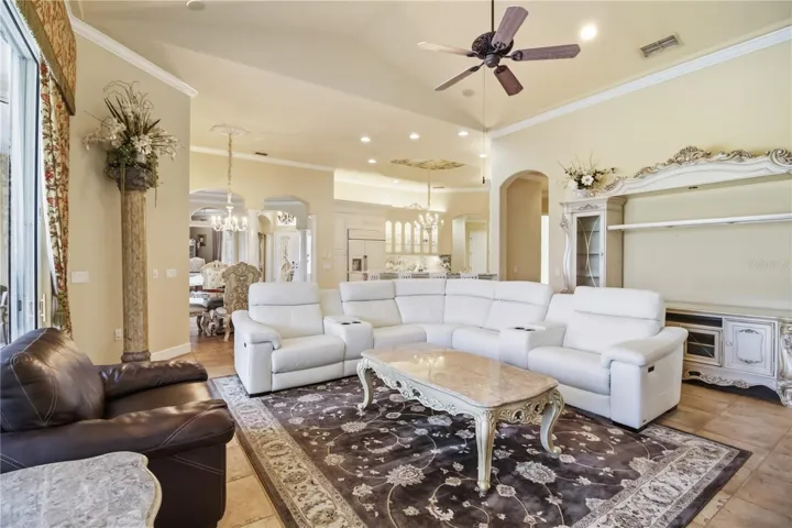 Open gathering space with fireplace, tray ceiling, and expansive glass doors.