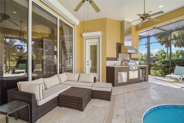 Spacious covered lanai with lounge seating, pool access, and shaded comfort.