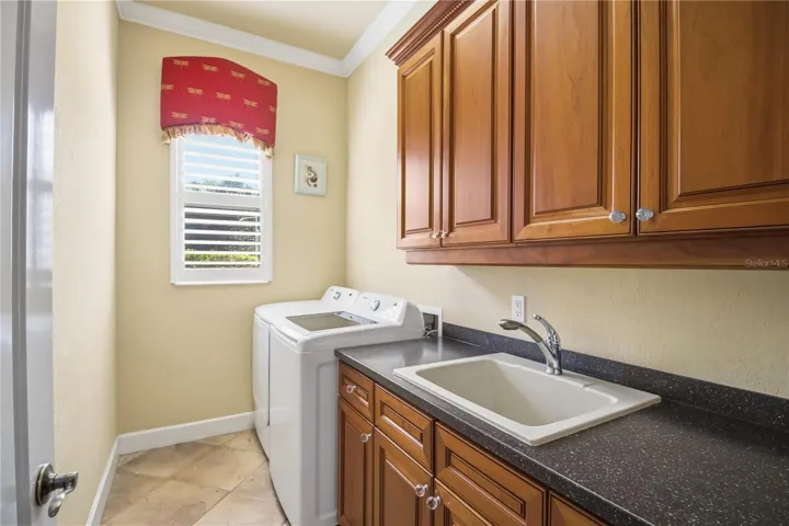 Laundry room with cabinetry, sink, and practical workspace.