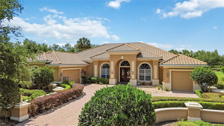 Elegant front elevation with circular drive, manicured landscaping, and private curb appeal.
