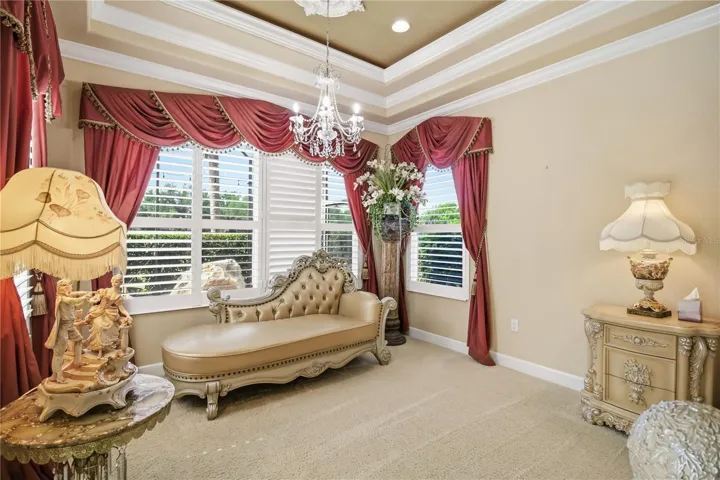 Primary suite lounge area overlooking the golf course and pool
