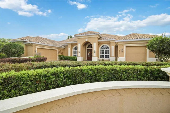 Private estate-style curb appeal with a grand entrance and lush landscaping.