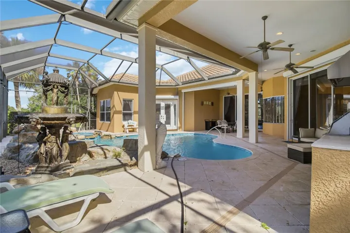 Expansive screened lanai with covered living space and poolside lounging.