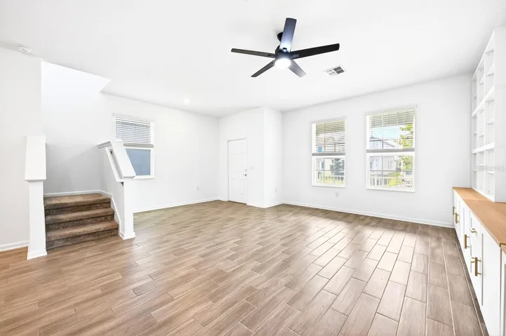 Step inside to a spacious Living Room featuring a CUSTOM FLOOR-TO-CEILING ENTERTAINMENT CENTER (2023), providing both a stunning focal point and functional storage.