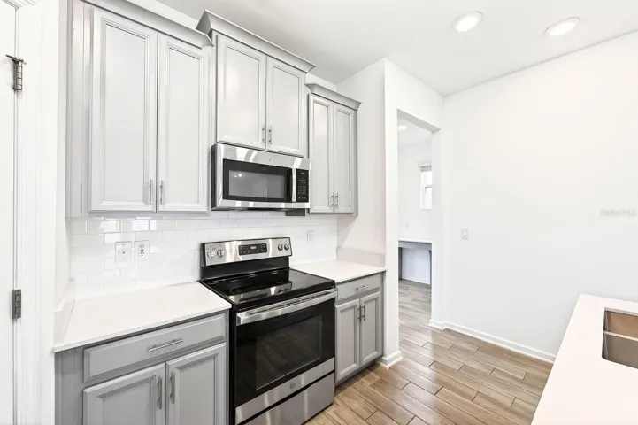 The Kitchen is bright and welcoming, featuring stainless steel appliances, a SUBWAY TILE BACKSPLASH, a closet pantry, and a breakfast bar, making it perfect for casual meals or entertaining.
