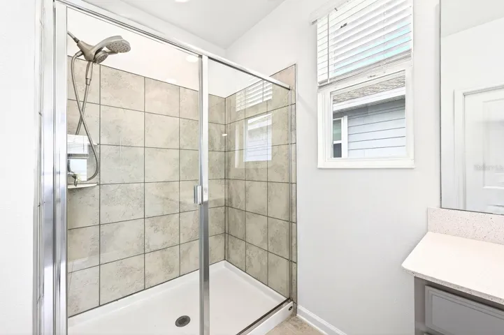 The Primary en suite bath boasts dual sinks and a step-in shower with UPGRADED SHOWERHEAD (2023).