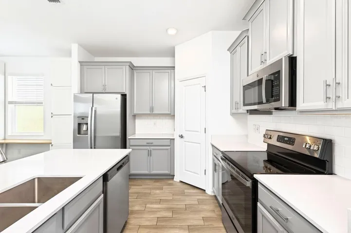 The Kitchen is bright and welcoming, featuring stainless steel appliances, a SUBWAY TILE BACKSPLASH, a closet pantry, and a breakfast bar, making it perfect for casual meals or entertaining.
