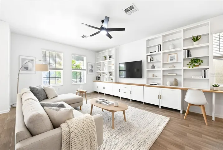 Step inside to a spacious Living Room featuring a CUSTOM FLOOR-TO-CEILING ENTERTAINMENT CENTER (2023), providing both a stunning focal point and functional storage. Virtually Staged