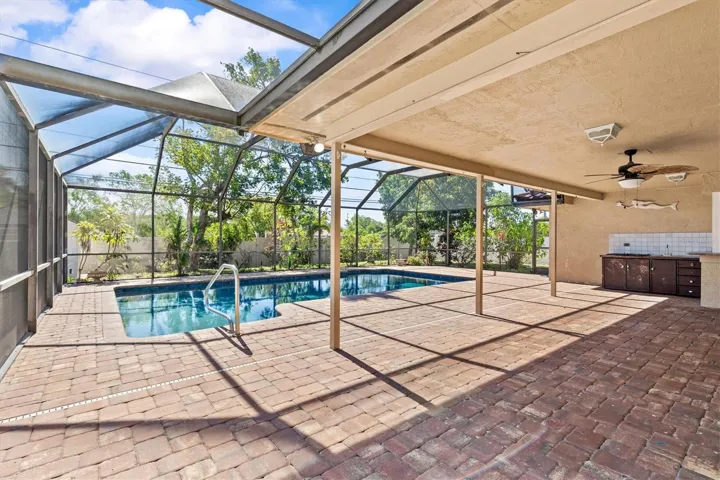 Screened-in pool with covered outdoor living area—perfect for relaxing, dining, and enjoying Florida living in comfort.