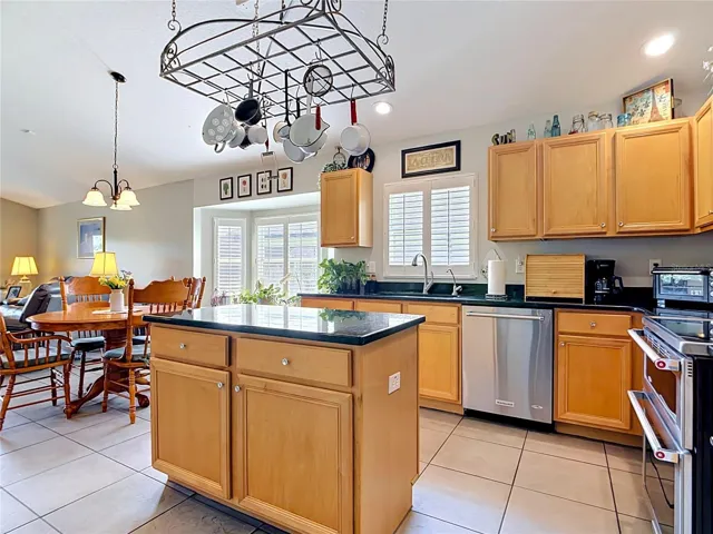 Large eat-in kithcen with granite countertops, stainless steel appliances opens to family room.
