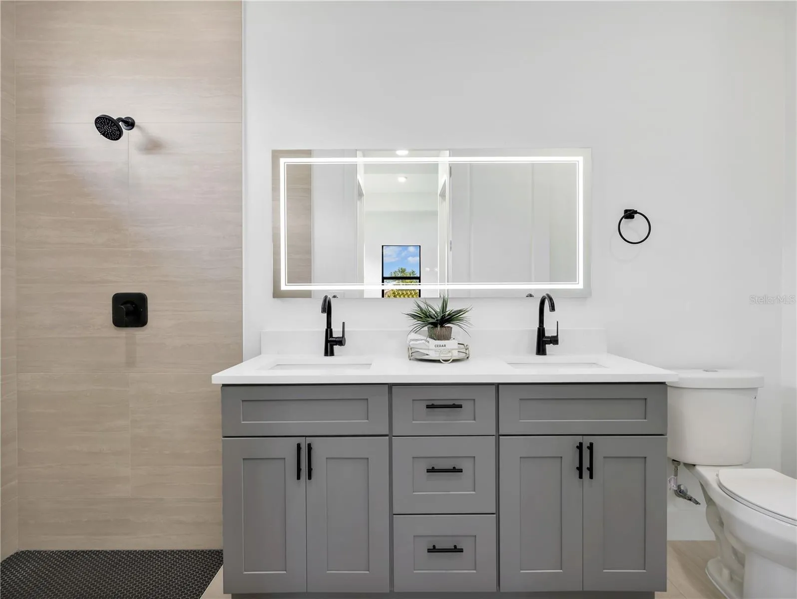 Bathroom featuring a dual vanity with grey abinetry, white countertops, and matte black fixtures photos used from another listing to show what it would look like with furniture