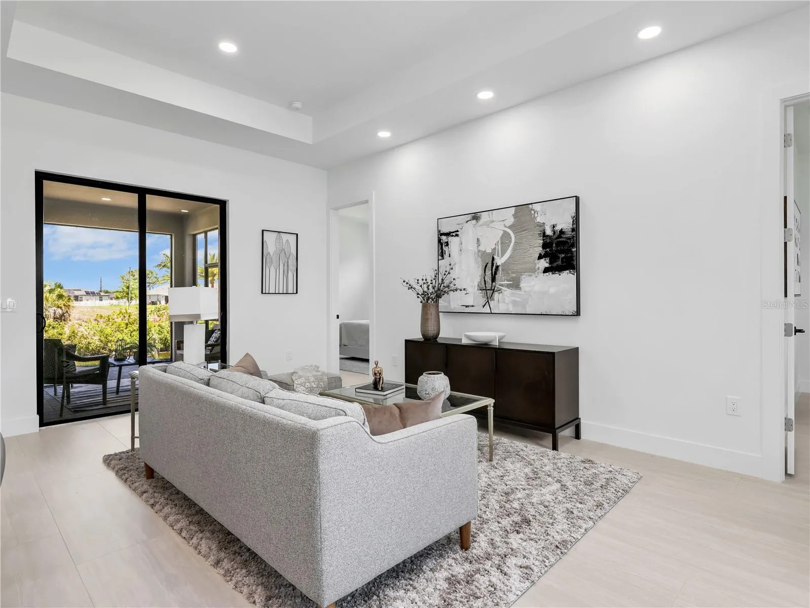 Living area featuring recessed lighting, a tray ceiling, and light wood-finish flooring photos used from another listing to show what it would look like with furniture