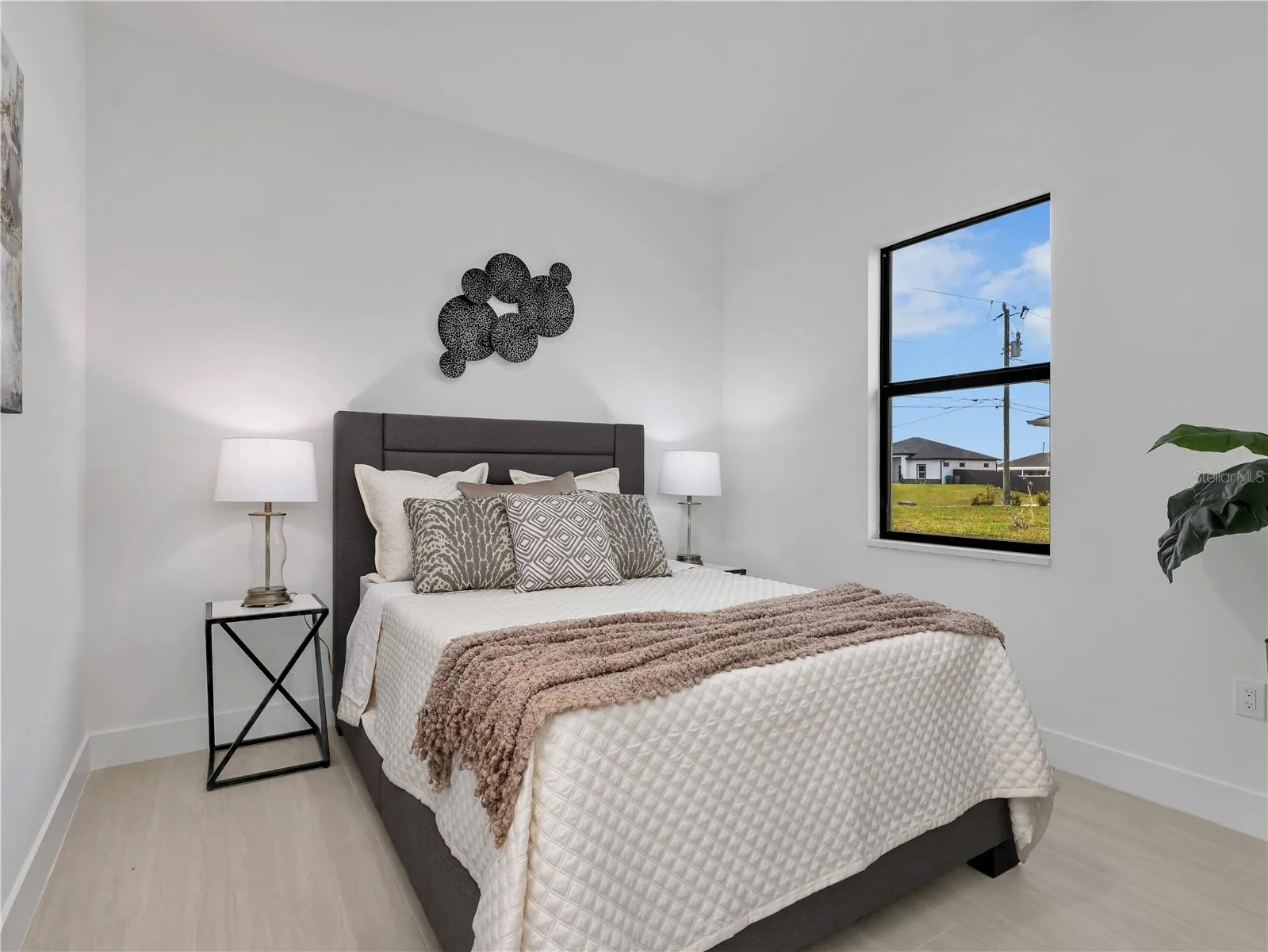 Bright interior with light wood-finish flooring and a large window photos used from another listing to show what it would look like with furniture