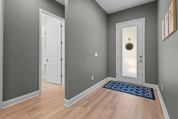 The entry opens to high ceilings and luxury vinyl plank flooring throughout the main living areas.