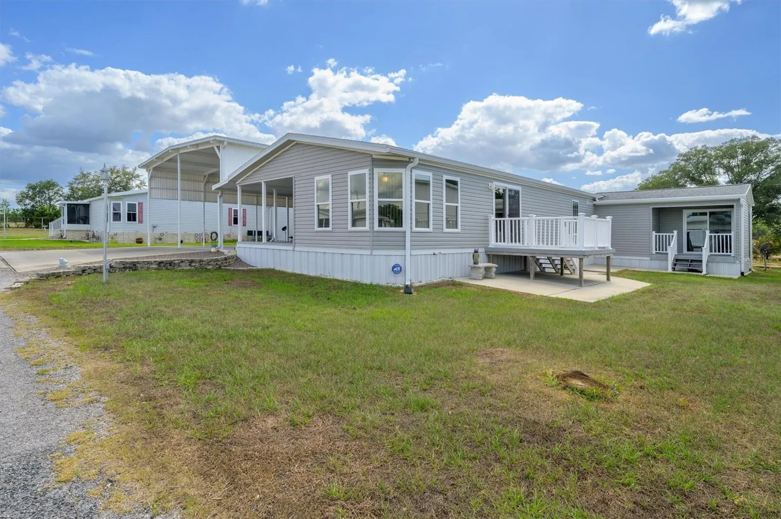 This photo shows large lot with deck from living room,  and then the separate entrance into the flex room currently being used as an office, but which could a den, storage, etc.