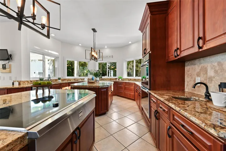 The chef’s kitchen is as functional as it is beautiful, featuring custom cabinetry, stone countertops, a custom cooktop installed in 2026, & all the space you need! The kitchen flows seamlessly into the home’s expansive gathering spaces, making it ideal for hosting on any scale