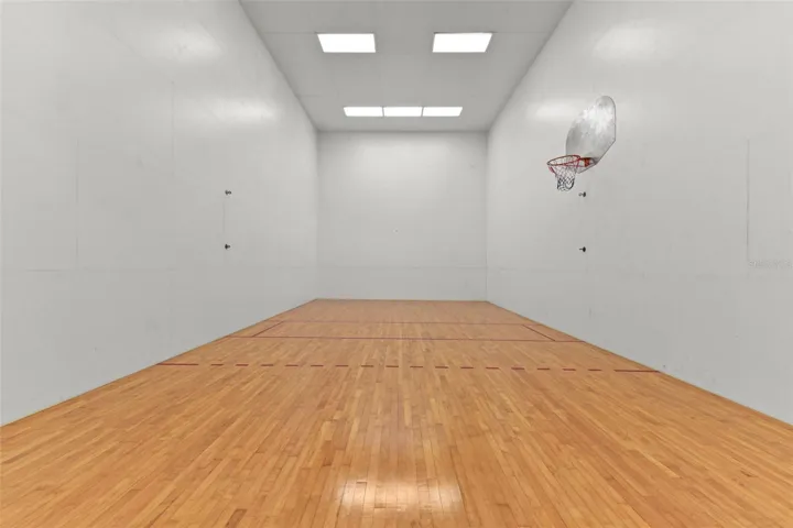 Indoor sports court, accessible from the outdoor pool and entertainment area and currently equipped with a basketball hoop while also offering flexibility for volleyball, pickleball, handball or other recreational use