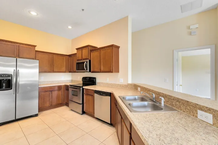 The Kitchen offers AMPLE CABINETRY and COUNTER SPACE, stainless steel appliances, and a convenient breakfast bar, making it both functional and welcoming.