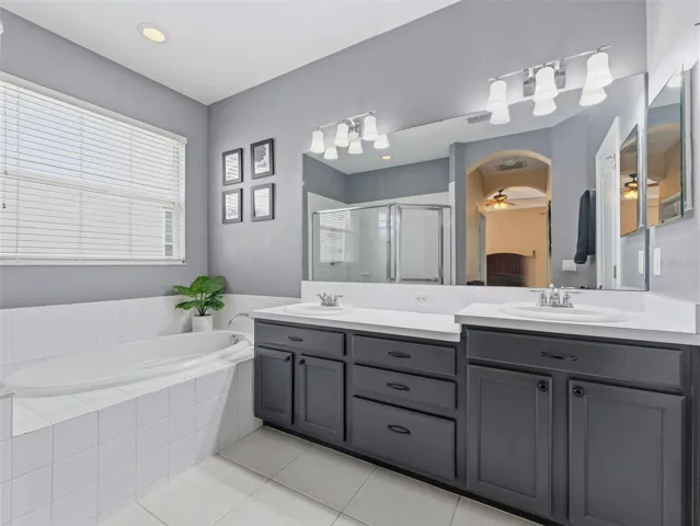 Primary bath features garden tub, dual sinks, and large shower with glass enclosure; private water closet too
