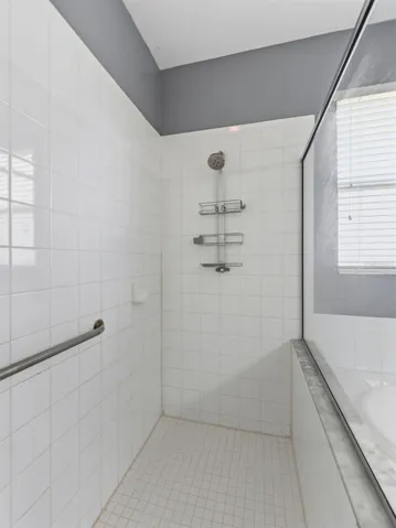Gleaming white tile in large walk-in shower