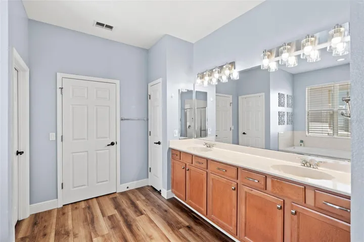 The Primary EN SUITE BATH boasts dual vanities, a soaking garden tub, a step-in shower, and a spacious walk-in closet.