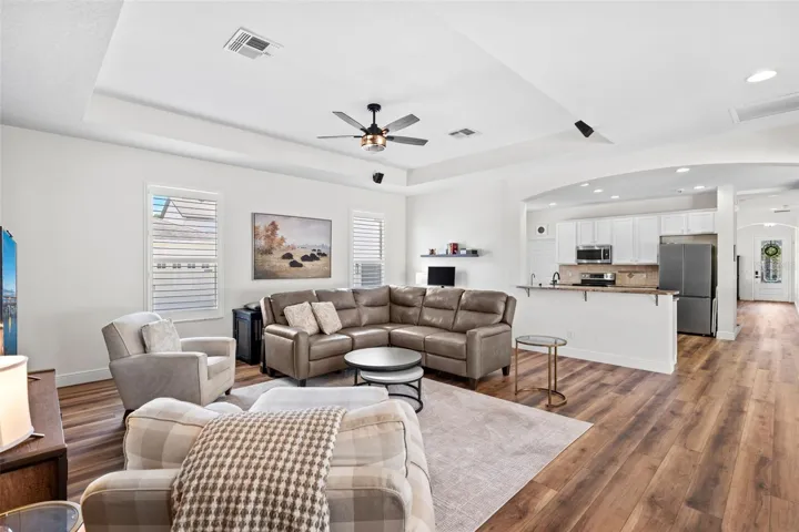 The Family Room exudes comfort and style, featuring a TRAY CEILING and corner sliding doors that open to a paver patio.