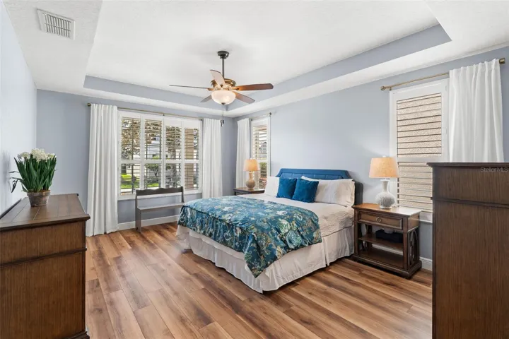 The Primary Suite, thoughtfully located on the main level, is a true retreat, offering GENEROUS PROPORTIONS, a tray ceiling, abundant natural light, and a LUXURIOUS EN SUITE BATH complete with dual vanities, a soaking garden tub, a step-in shower, and a spacious walk-in closet.