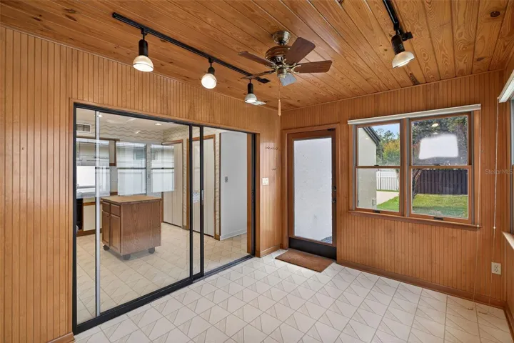 Wood-paneled bonus room or sunroom offering flexible space for an office, lounge, or hobby area.
