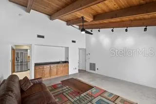 Additional view of the main living room showcasing the vaulted ceilings and built-in wet bar.