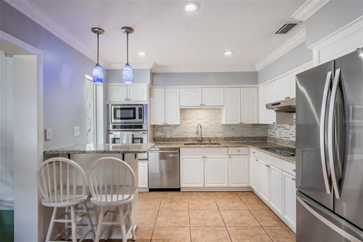 modernized light and bright kitchen featuring stainless appliances