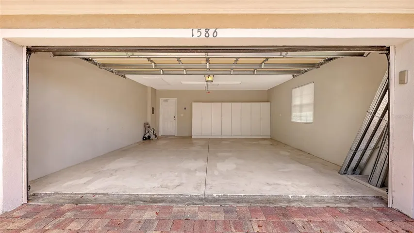 Garage with hurricane shutters and cabinets.
