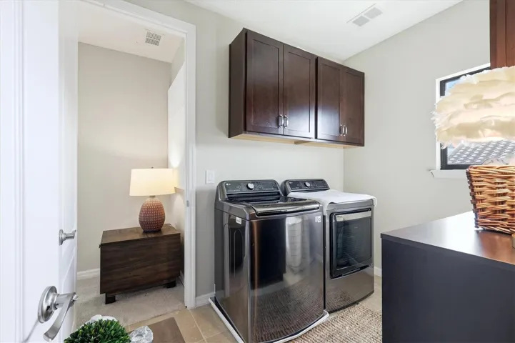 Laundry room connected to primary suite with access to guest hallway.