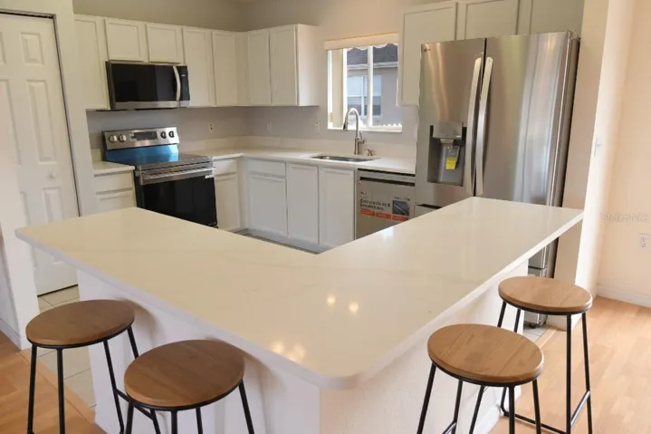 Updated Kitchen with Tile Flooring Staged with Interior Barstools