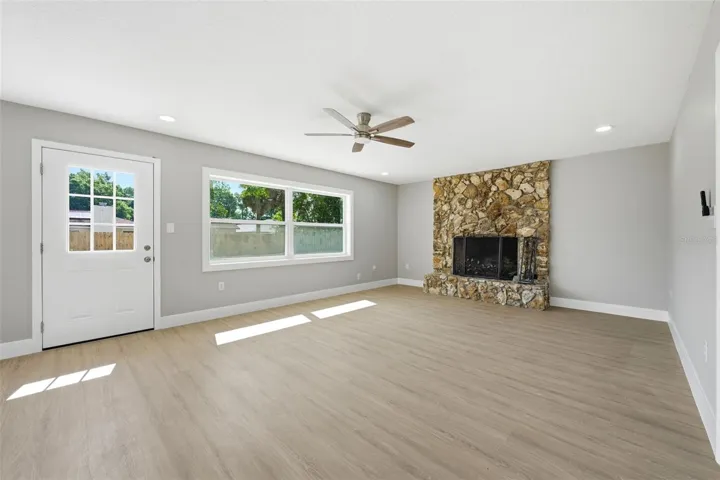 Spacious main living area with large windows and fireplace feature