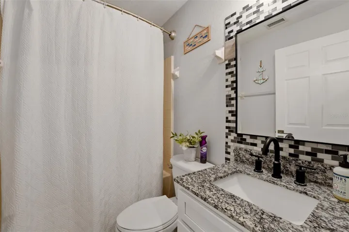 Updated bathroom with modern vanity and tile backsplash