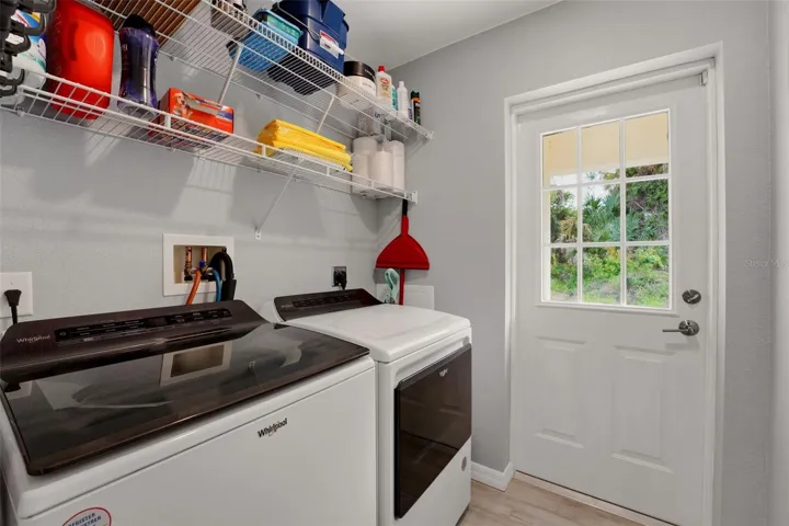 Dedicated laundry room with washer, dryer, and added shelves for storage