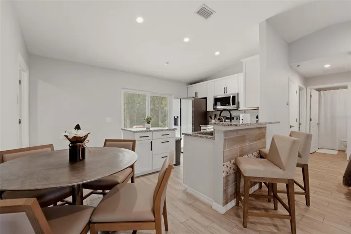 Open concept layout connecting living, dining, and kitchen