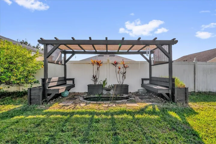 Fenced backyard with Pergola and fountain