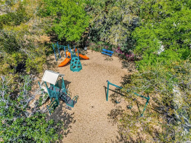 Community playground area surrounded by mature landscaping, offering a great outdoor space for recreation and leisure