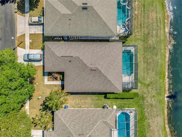 Aerial view highlighting the home’s premium lot, private screened pool, and scenic waterfront setting