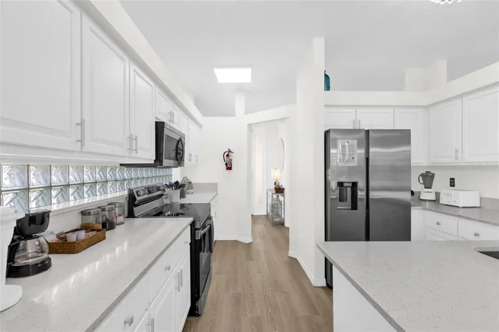 Updated kitchen with stainless steel appliances, quartz counters, and ample cabinetry